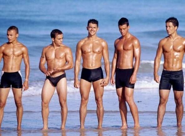 bărbați pe plajă cu cocoși mari